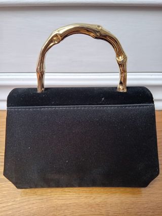 Bolso de mano negro con asa dorada