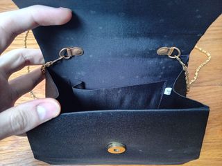 Bolso de mano negro con asa dorada