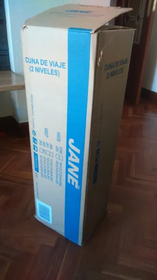 Cuna de viaje plegable roja y negra.