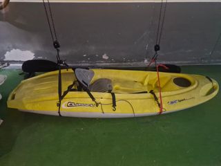 Kayak amarillo y blanco. Con remo y bancada