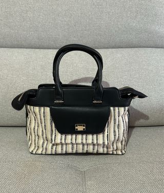 Bolso de mano beige y negro.