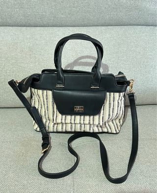 Bolso de mano beige y negro.