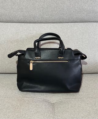 Bolso de mano beige y negro.