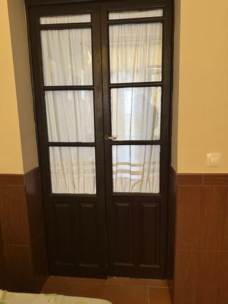 Puerta de madera oscura con cristal