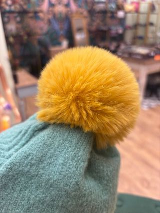 Gorro de lana verde con pompón amarillo