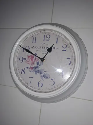 Reloj de pared blanco con flores.