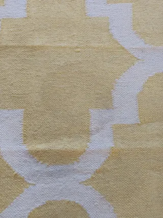 Alfombra amarilla y blanca con diseño geométrico