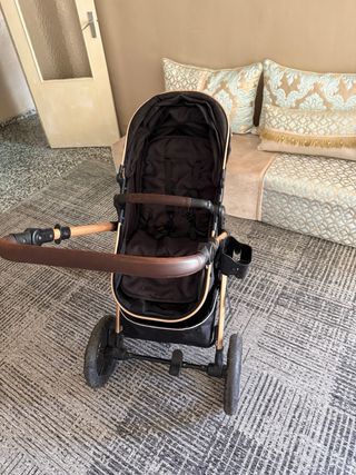 Carrito de bebé negro y dorado