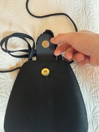 Bolso de mano negro con flecos