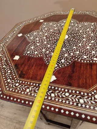 Mesa octogonal artesanal con incrustaciones.