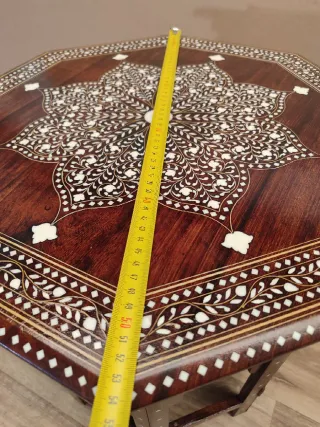 Mesa octogonal artesanal con incrustaciones.