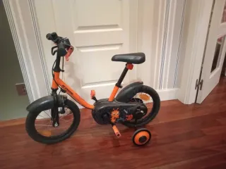 Bici infantil naranja con ruedines