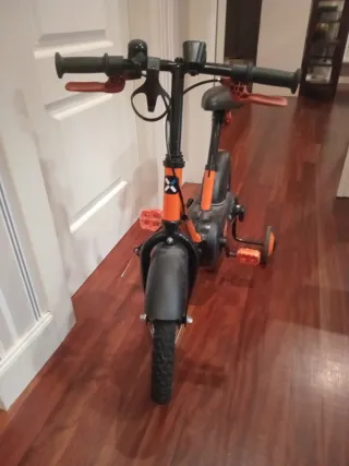 Bici infantil naranja con ruedines