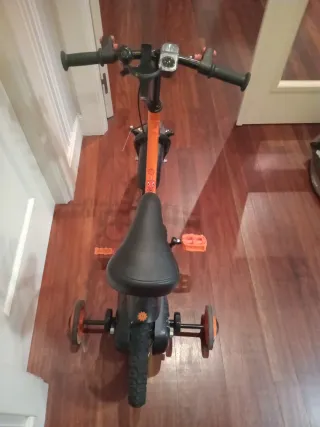 Bici infantil naranja con ruedines