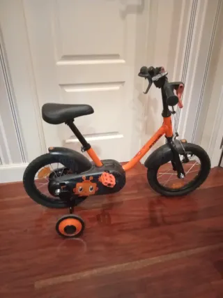 Bici infantil naranja con ruedines