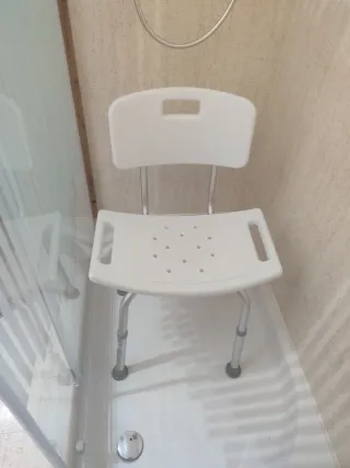 Silla de ducha blanca con respaldo
