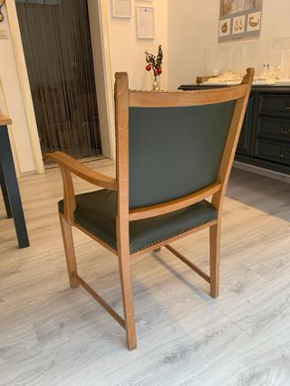 Silla de madera con brazos y tapizado verde