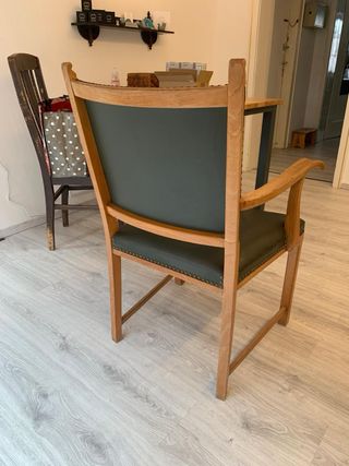 Silla de madera con brazos y tapizado verde