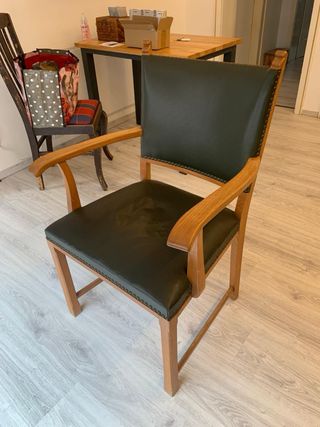 Silla de madera con brazos y tapizado verde