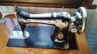 Máquina de coser antigua con mueble de madera.