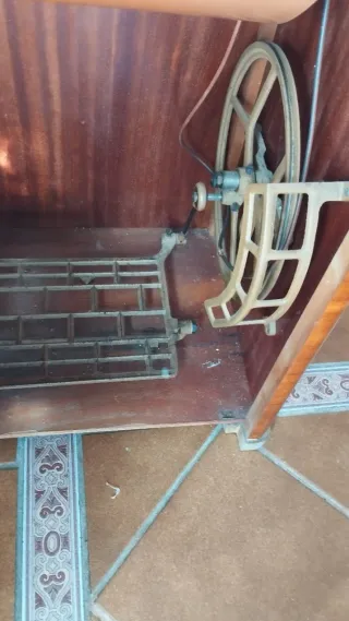 Máquina de coser antigua con mueble de madera.