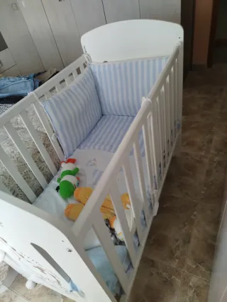 Cuna blanca con diseño de dinosaurio