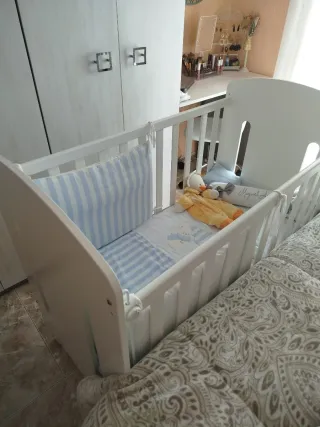 Cuna blanca con diseño de dinosaurio