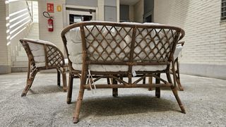 Sofá y sillones de mimbre con mesa de cristal