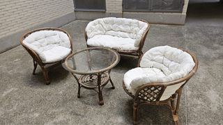 Sofá y sillones de mimbre con mesa de cristal