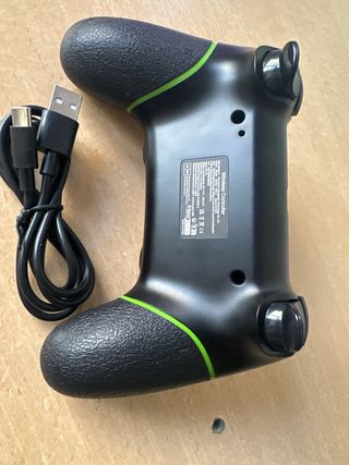 Mando de videojuegos negro con detalles verdes