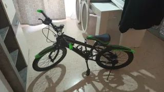 Bicicleta infantil negra y verde usada par de vece
