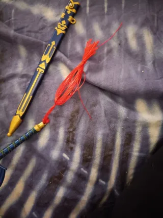 Espada decorativa azul con flecos rojos