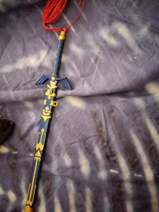 Espada decorativa azul con flecos rojos