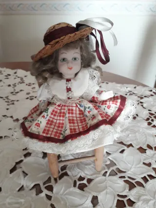 Bambola in ceramica su sedia. Vintage