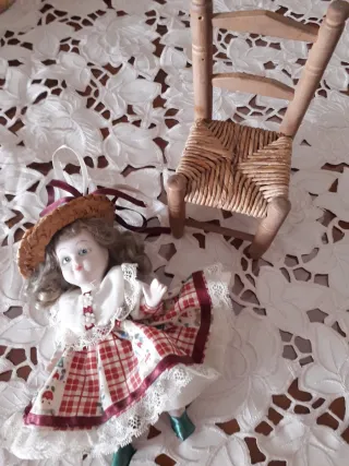 Bambola in ceramica su sedia. Vintage