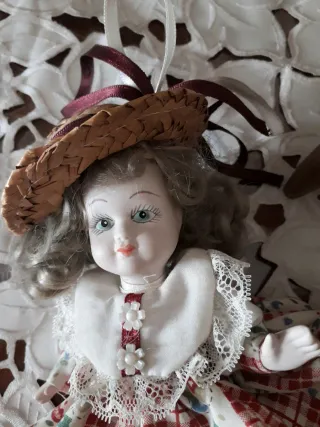 Bambola in ceramica su sedia. Vintage