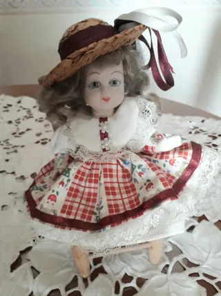 Bambola in ceramica su sedia. Vintage