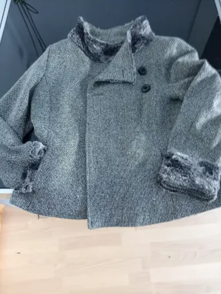 Chaqueta gris y negra con cuello de pelo