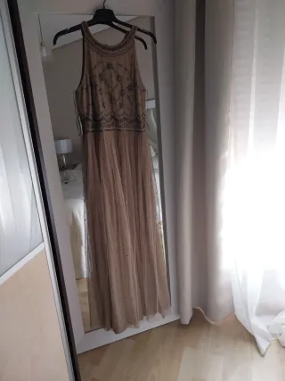 Vestido largo beige y dorado con pedrería.