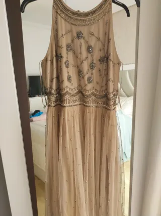 Vestido largo beige y dorado con pedrería.