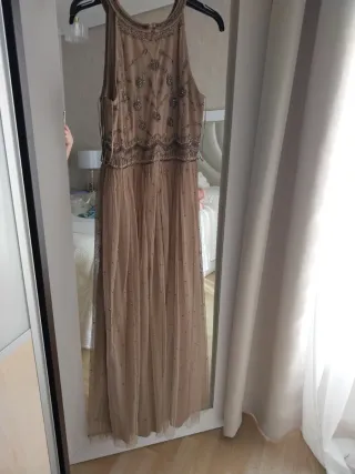 Vestido largo beige y dorado con pedrería.