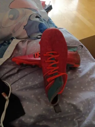 Botas de fútbol naranjas y turquesa