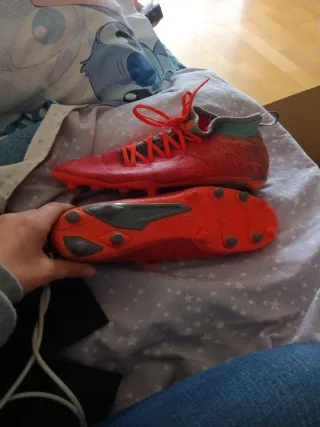 Botas de fútbol naranjas y turquesa