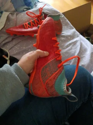 Botas de fútbol naranjas y turquesa