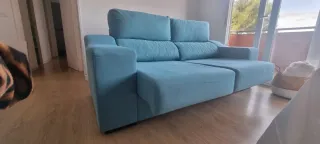 Sofá de tela azul turquesa.