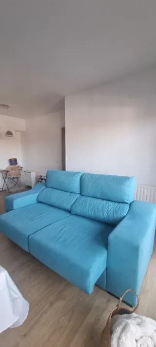 Sofá de tela azul turquesa.
