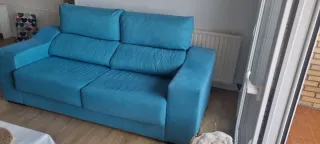Sofá de tela azul turquesa.