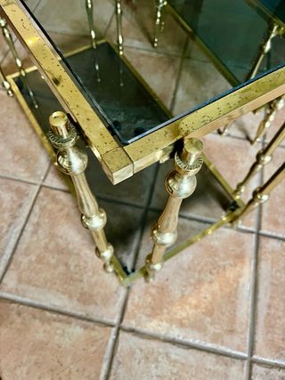 Mesa auxiliar cristal oscuro y metal dorado
