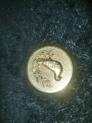 Medalla de oro con ave y rama