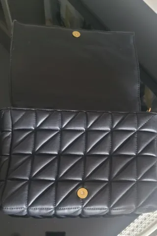 Bolso negro acolchado con cadena dorada